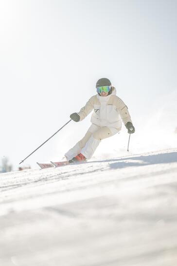 Ein Skifahrer fährt auf einer verschneiten Piste bergab