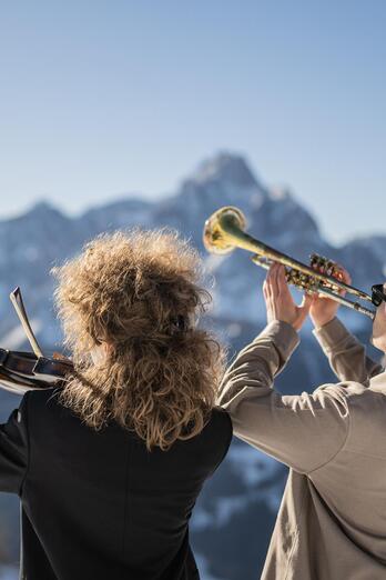 Ein Mann spielt Trompete, während eine Frau neben ihm Violine spielt