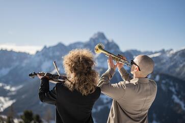 Ein Mann spielt Trompete, während eine Frau neben ihm Violine spielt