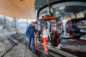 Ein Mann und eine Frau in Skiausrüstung steigen aus dem Skilift