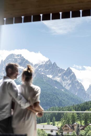 Ein Mann und eine Frau blicken auf eine Berglandschaft