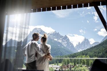 Ein Mann und eine Frau blicken auf eine Berglandschaft