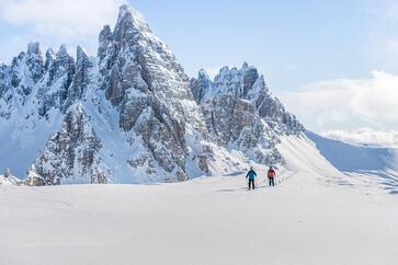 Zwei Personen beim Schneeschuhwandern um den Drei Zinnen