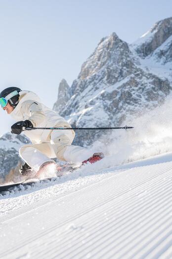 Ein Skifahrer fährt auf einer verschneiten Piste bergab